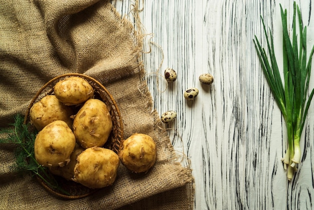 Potatoes onions quail eggs on a white table