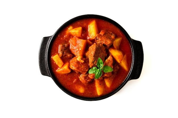 Potatoes stewed with meat in tomato sauce with spices and herbs no people on a white table