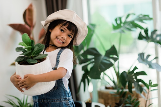 Potted plants at home held by a cute kid