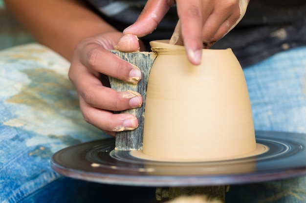 Potter creating clay bowl on turning wheel