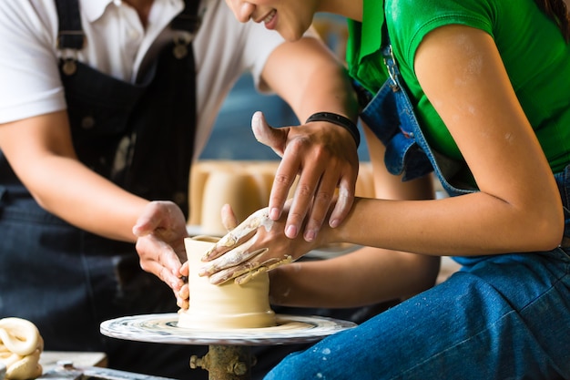 Potter creating clay bowl on turning wheel