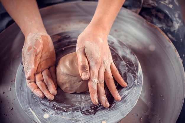 Potter female student working with pottery at the ceramic workshop. Concept for woman in freelance, business, hobby. Close-up.