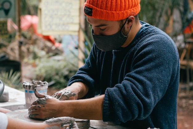 The potter works with clay craftsman39s hands nearby shaping with the clay The woman using the potter39s wheel in pottery