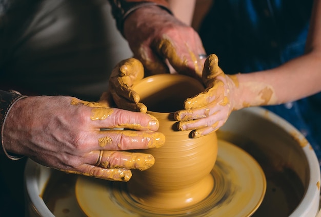 Pottery workshop. Grandpa teaches granddaughter pottery. Clay modeling.