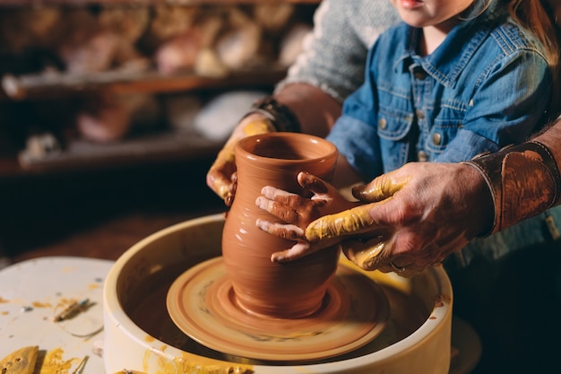 Pottery workshop. Grandpa teaches granddaughter pottery. Clay modeling