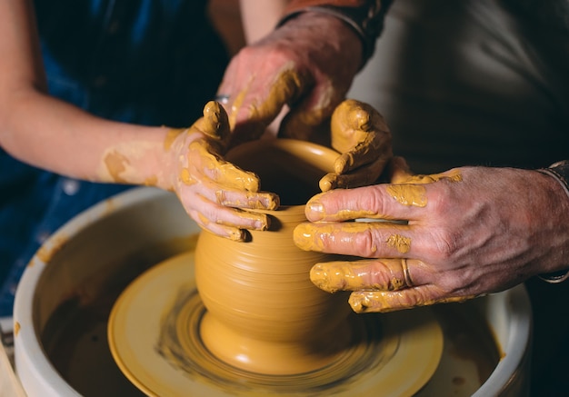 Pottery workshop. Grandpa teaches granddaughter pottery. Clay modeling