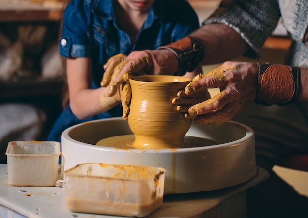 Pottery workshop. Grandpa teaches granddaughter pottery. Clay modeling