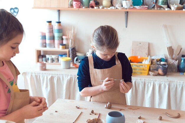 Photo pottery workshop for kids girl working with clay