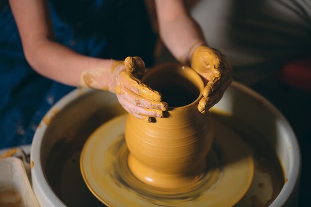 Pottery workshop. A little girl makes a vase of clay. Clay modeling