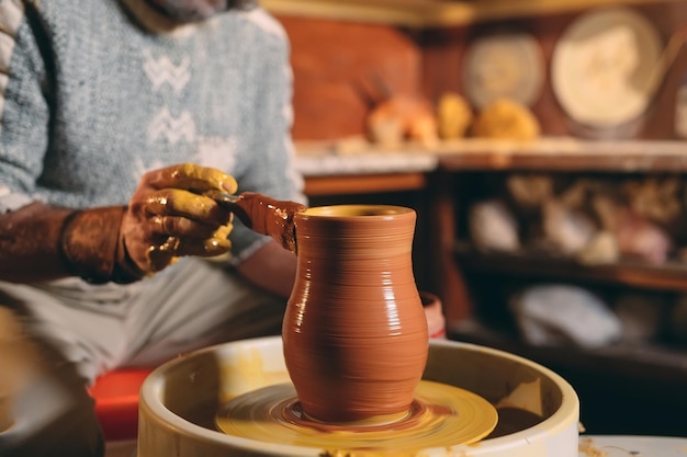 Pottery workshop. A senior man makes a vase of clay. Clay modeling.