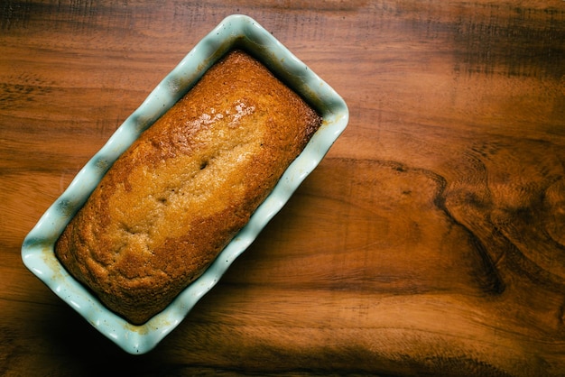 Pound cake in blue mold on wooden table