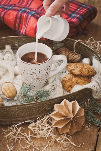 Pour the milk into a mug of cocoa and Christmas decorations