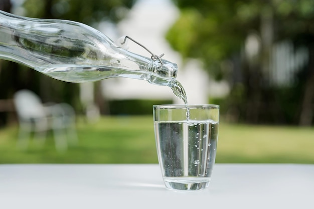 Pour the water from the water bottle into the glass