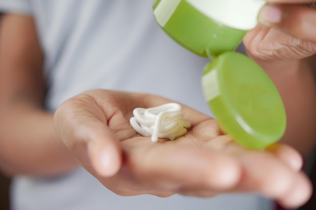 pouring aloe vera face cream on hand