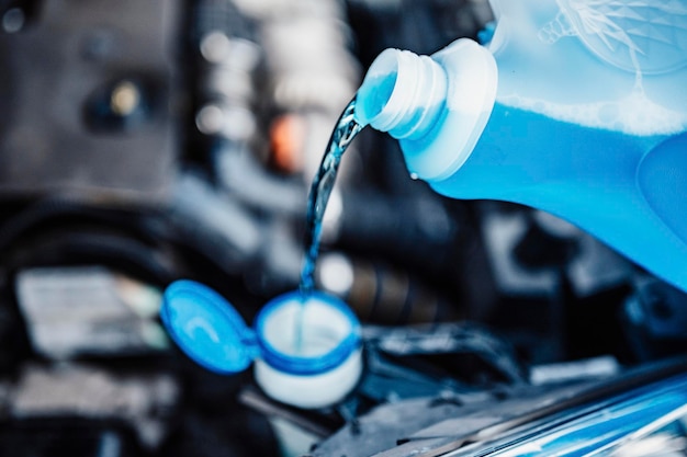 Pouring antifreeze Filling a windshield washer tank with an antifreeze in winter cold weather