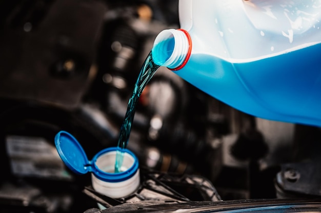 Pouring antifreeze Filling a windshield washer tank with an antifreeze in winter cold weather