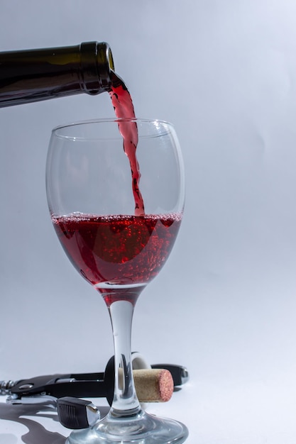 Pouring aromatic red wine from a bottle into a glass