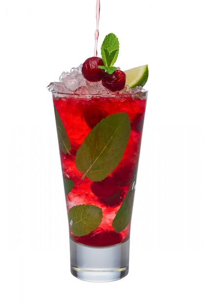 Pouring cherry juice to alcoholic cocktail with lime and mint isolated on white