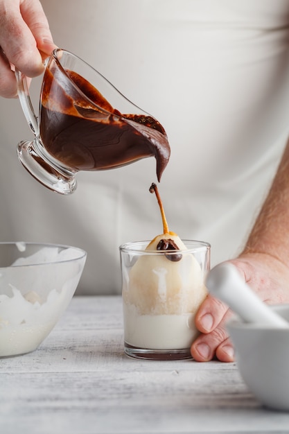 Pouring chocolate sauce onto ice cream