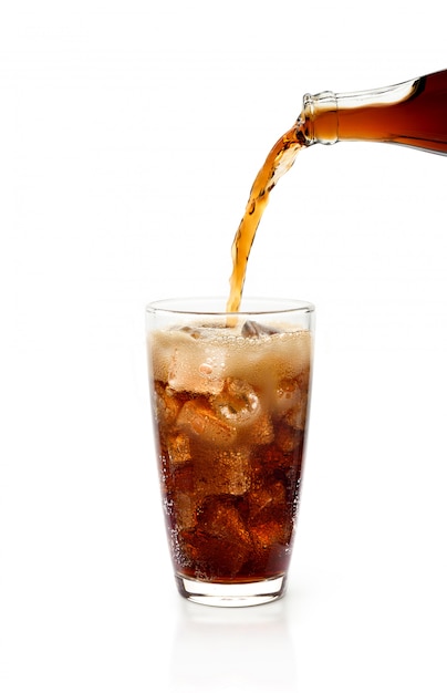 Pouring cola from bottle into glass with foam Isolated white background