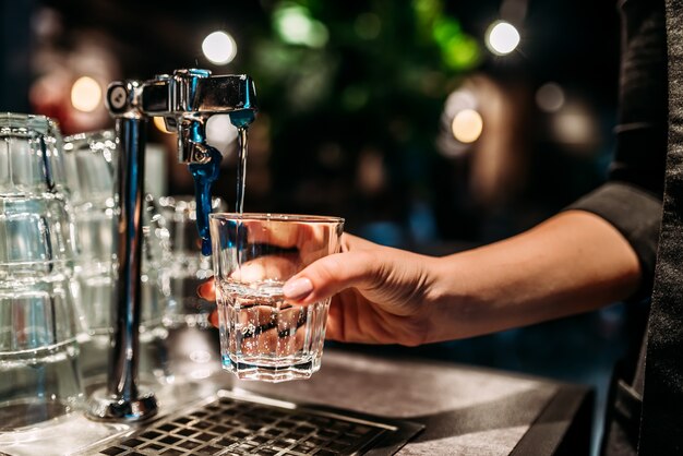 Pouring a glass of water from a tap.