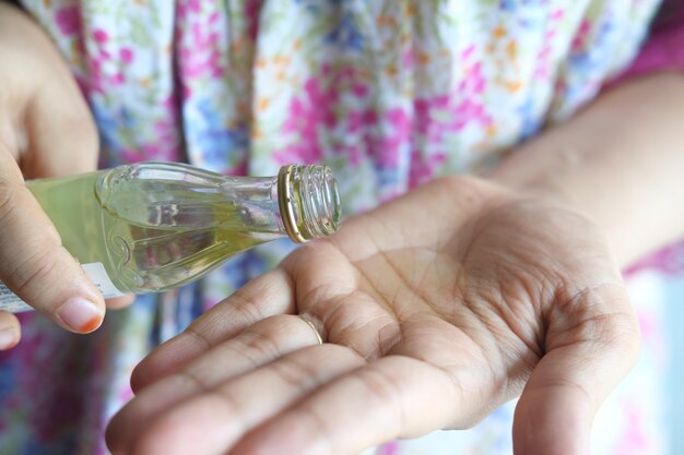 Pouring hair oil on hand close up