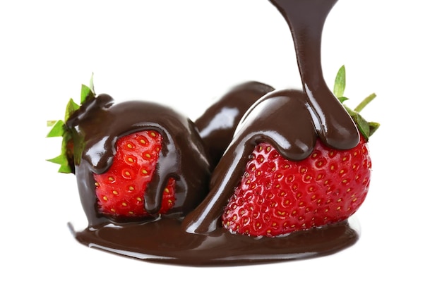 Pouring melted chocolate on juicy strawberries on white background