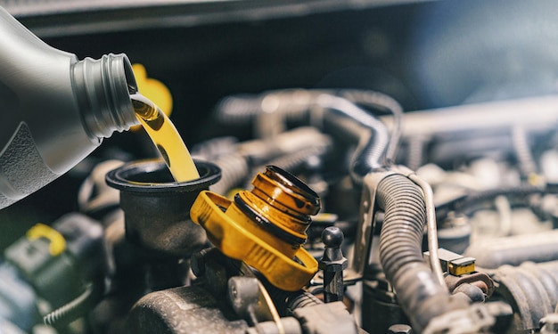 Pouring oil to car engine. Fresh oil poured during an oil change to a car.