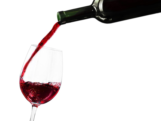 Pouring red wine in a glass isolated on white background