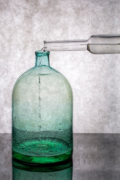 Pouring water from a bottle into a glass jar