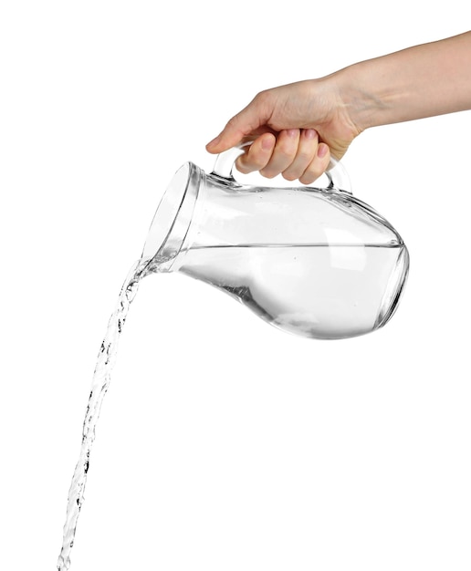 Pouring water from glass pitcher isolated on white