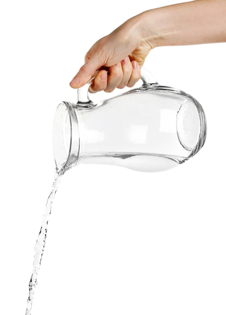 Pouring water from glass pitcher isolated on white