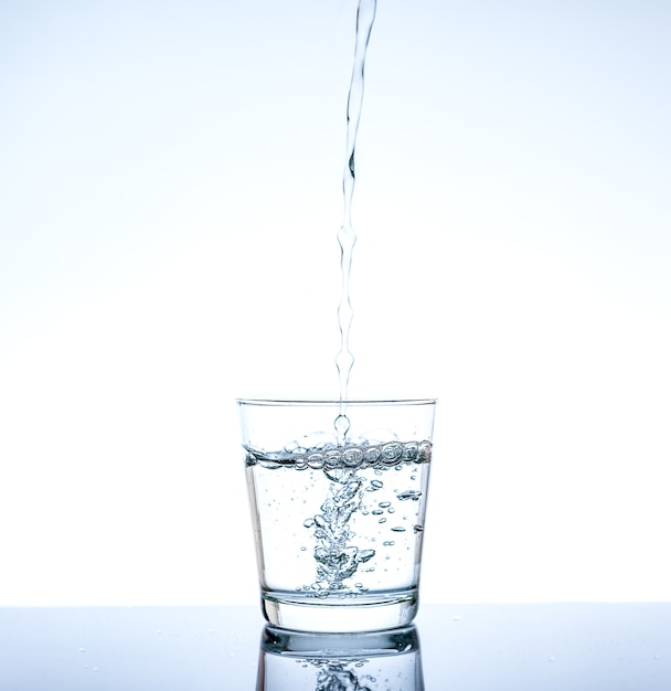 Pouring water and splashing in the glass 