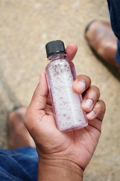 POV of hand hold a mouthwash liquid container