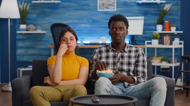 Pov of interracial couple watching movie on tv with snack