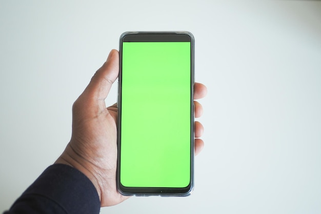 pov shot of young man hand using smart phone with green screen