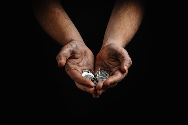 Poverty in ukraine dirty hands of a poor homeless man holding ukrainian hryvnias in coins