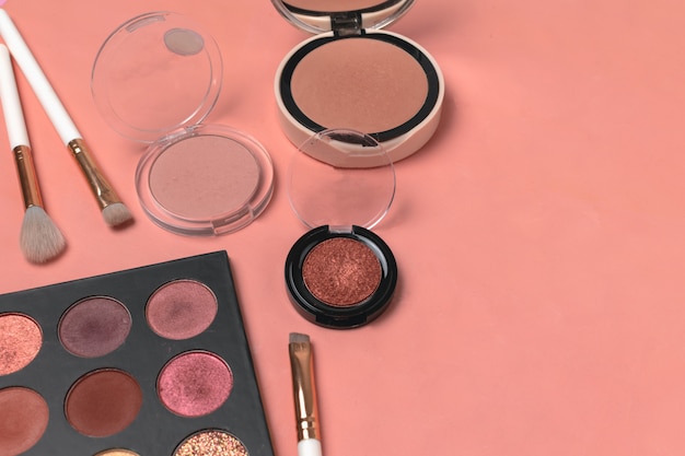 powder, eyeshadows, makeup brushes on trendy living coral 