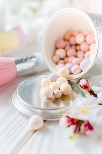 Powder for the face in balls on a light wooden table