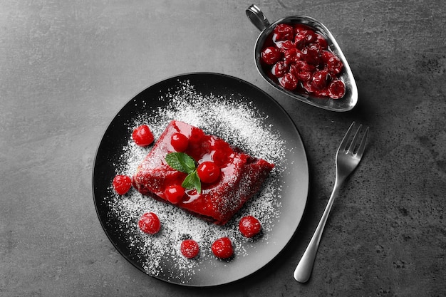 Powdered cherry strudel with mint on plate