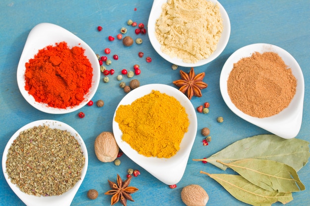 Powdered spices on blue  table close up