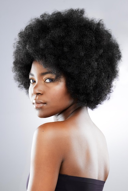 The power of the fro Studio portrait of an attractive young woman posing against a grey background