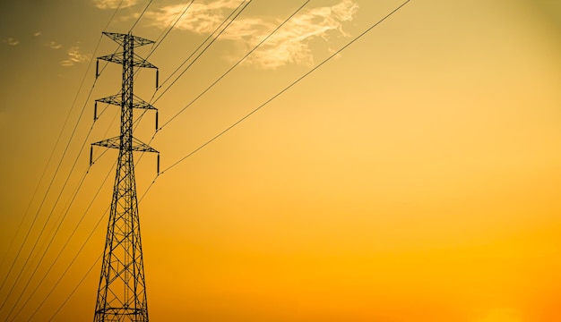 A power line with a yellow sky in the background