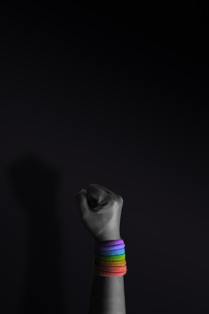 Power Protest and Expression for LGBTQ Rights Concept Closeup of Raise up Fist and Rainbow Wrist Strap Angry Ready to Punch Cropped and Selective Focus