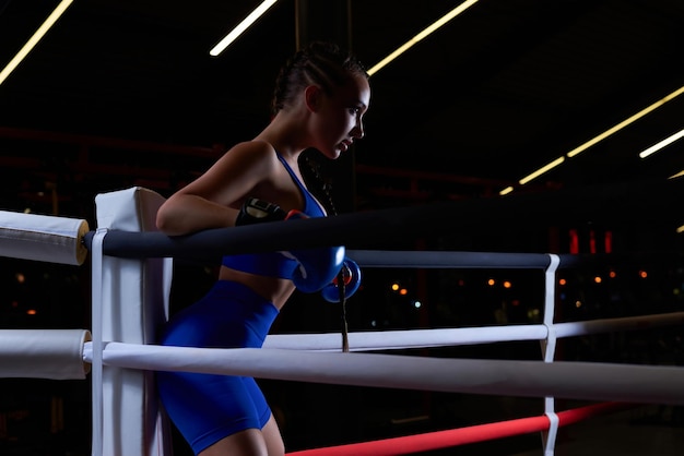 Powerful charged girl stands in the corner of the ring and is ready to explode in the next round The concept of wrestling and boxing