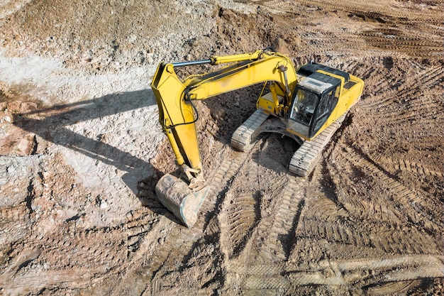 A powerful crawler excavator is working on a construction site Closeup View from above Preparation of a pit for construction Excavation