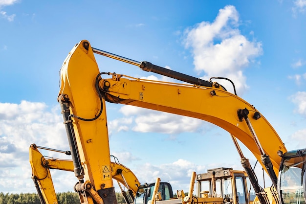 Powerful excavator at a construction site against a blue cloudy sky Earthmoving equipment for construction Development and movement of soil