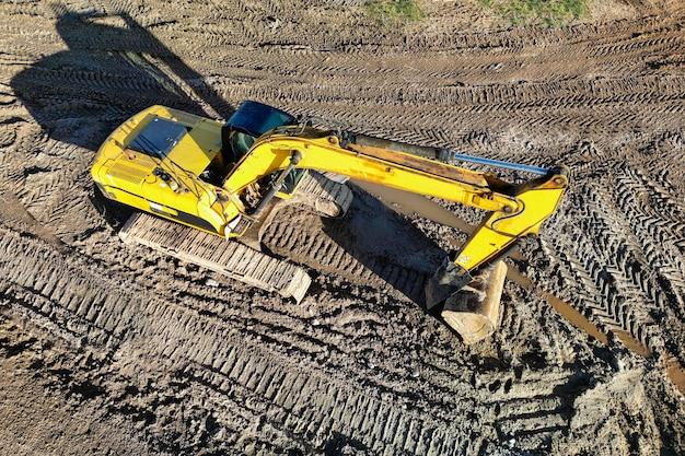 A powerful excavator digs the ground at a construction site View from above Drone photography Earthworks with heavy equipment at the construction site