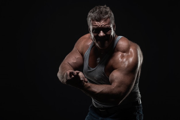 Powerful muscular man shows biceps 