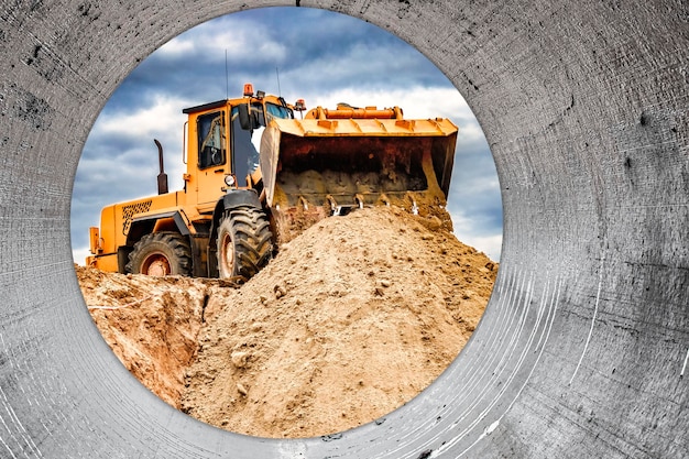 Powerful wheel loader or bulldozer working on a quarry or construction site Loader with a full bucket of sand against the sky Powerful modern equipment for earthworks